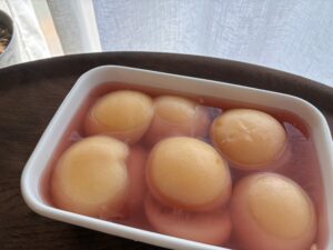 桃のコンポート。白い器のシロップに浸かった桃